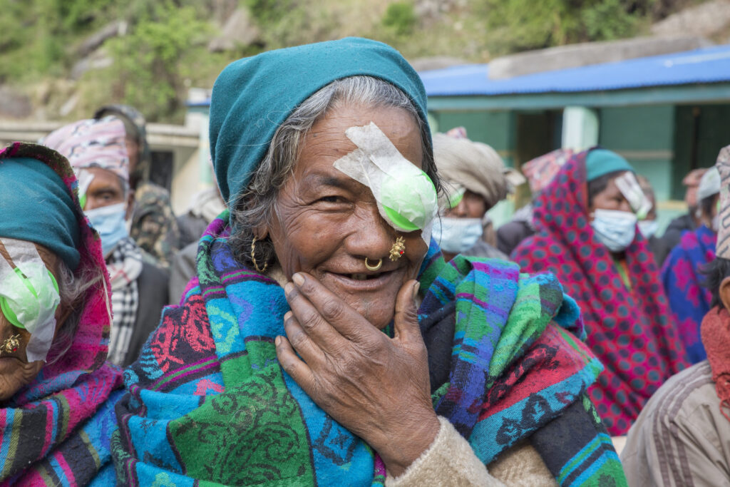 Double the difference donation impact - woman with bandage over her eye smiling at camera