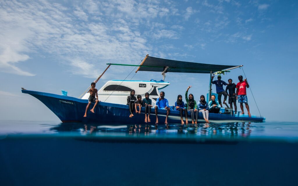 Double the difference donation impact - people sitting on a boat in the middle of the sea