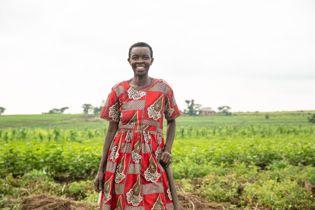 Double the difference donation impact - woman in red dress smiling with farm in the background