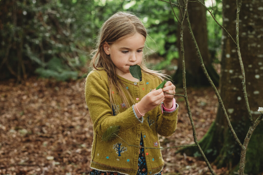 Double the difference donation impact - girl in woods holding leaves